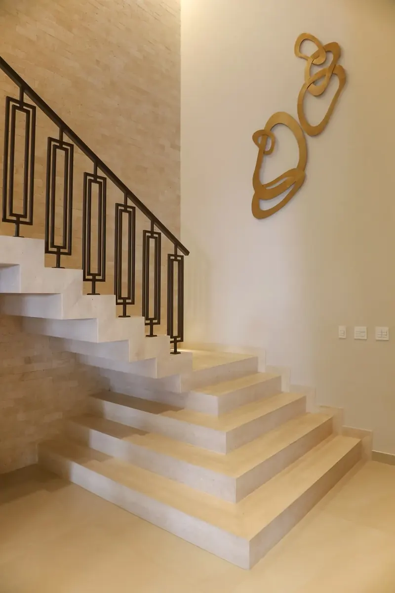 Escada em travertino com guarda-corpo em metal