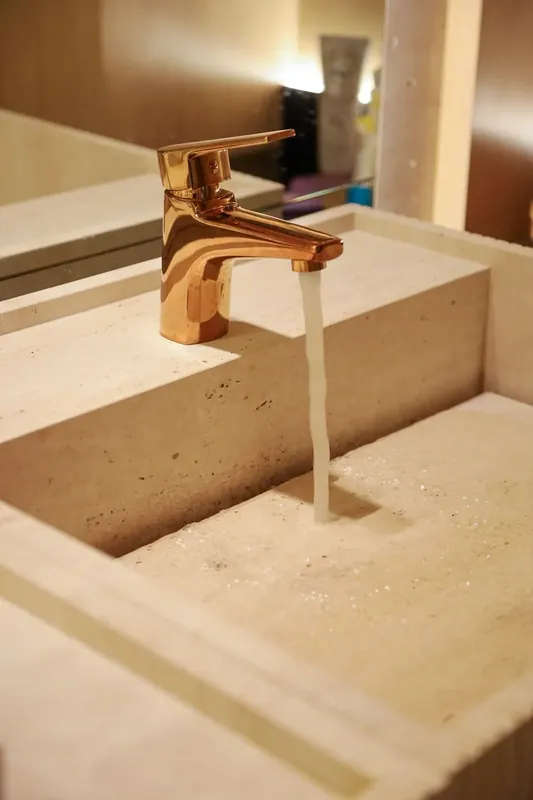 Travertino aplicado em bancada e cuba esculpida